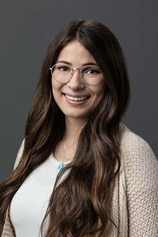headshots for the entire office portrait of team member wearing glasses with long hair