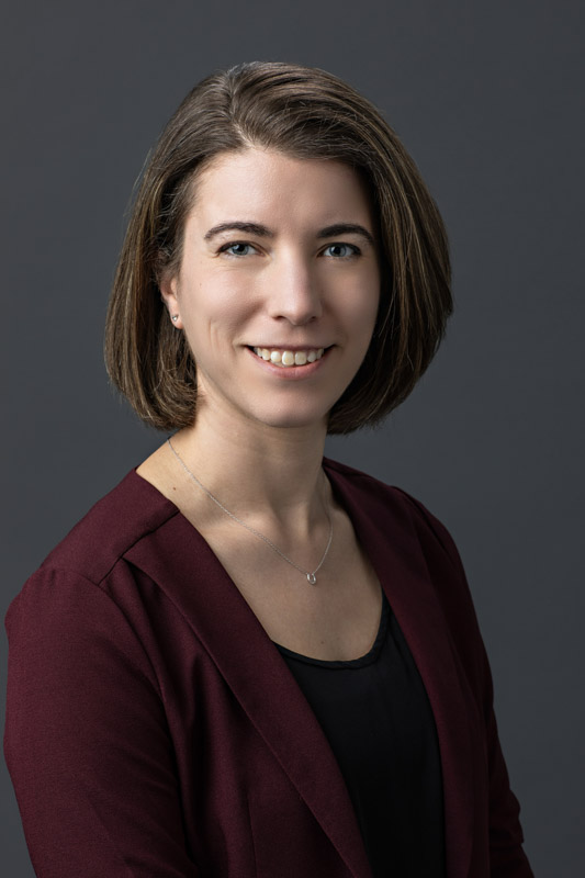 headshot portrait of team member wearing maroon sweater