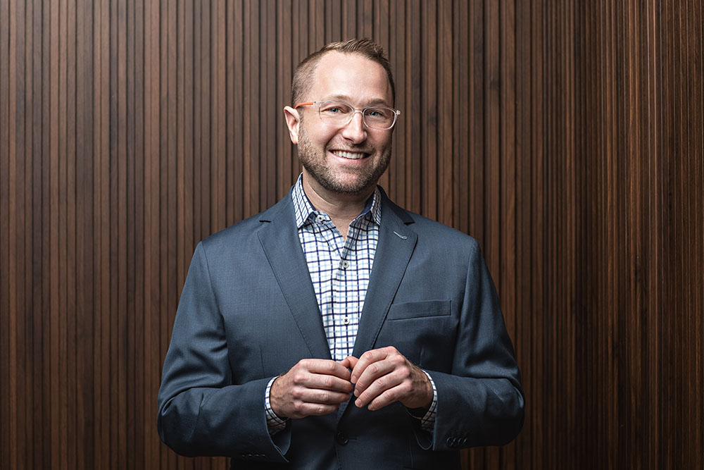 man poses against wood slats for his executive corporate portrait