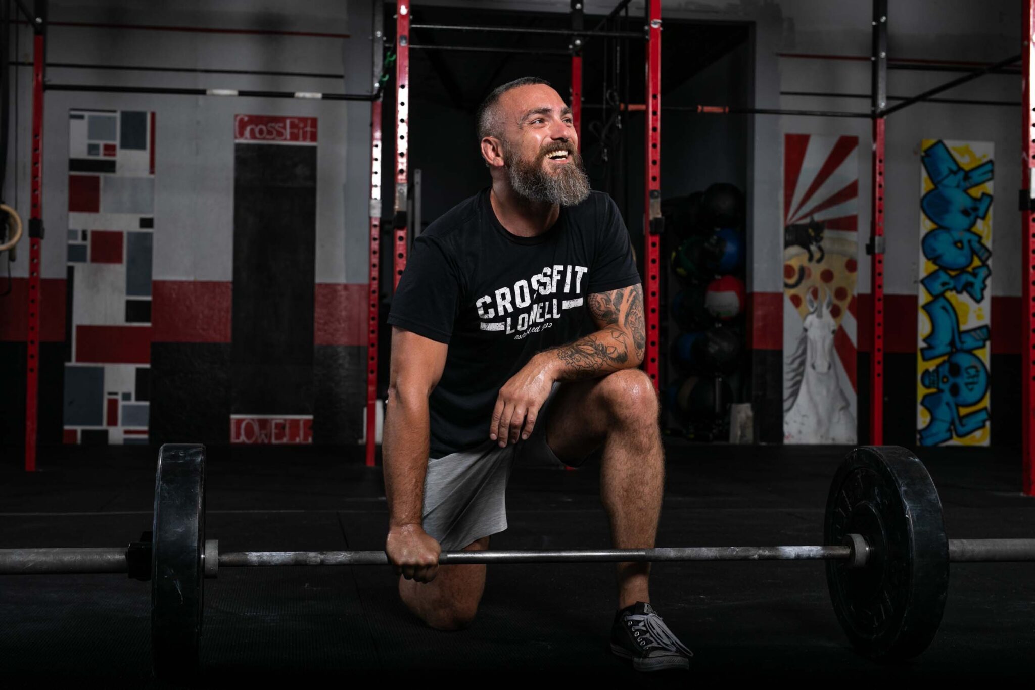 C18_CrossfitLowell_009_web image of a crossfit coach kneeling with barbell