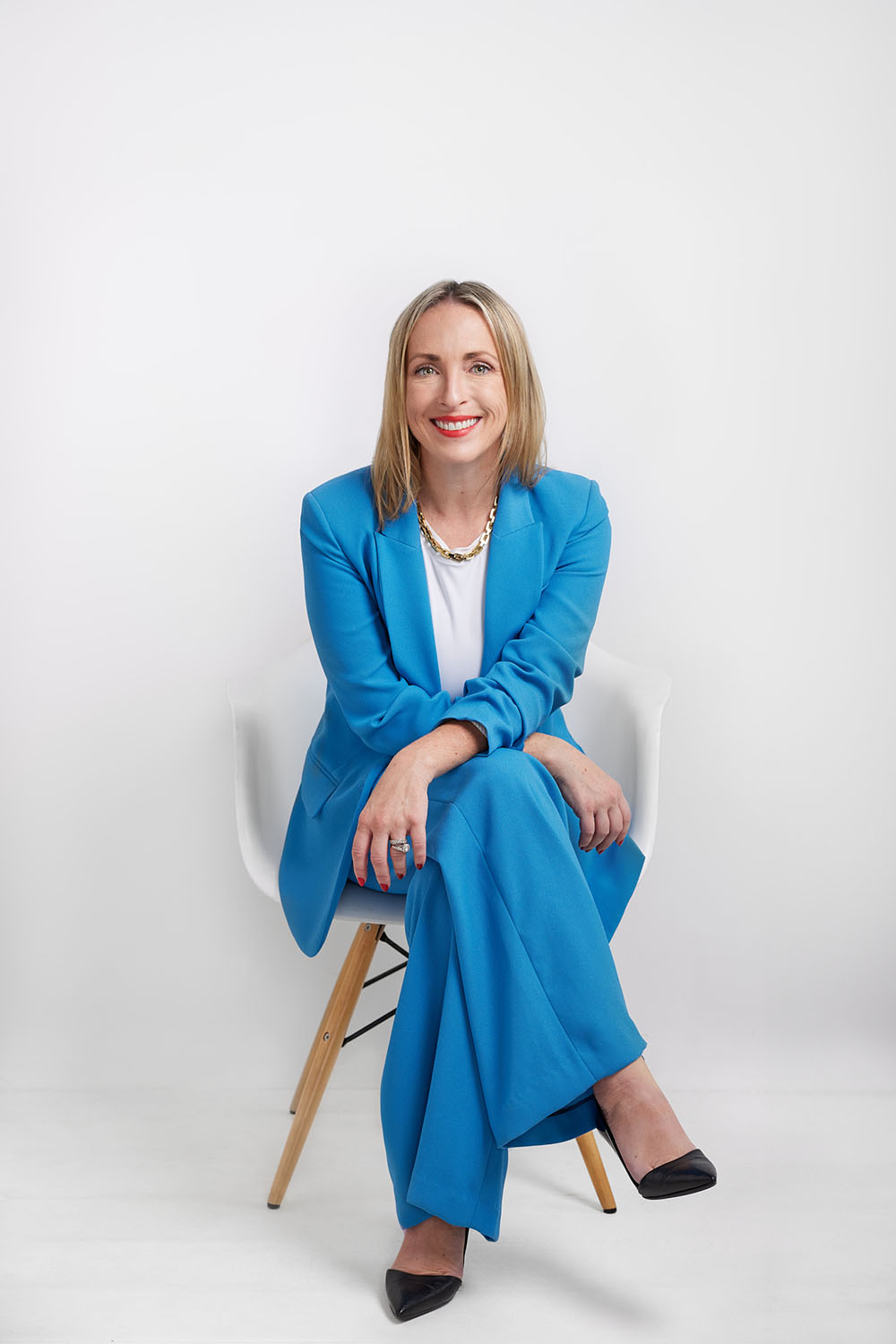 personal branding portrait of a woman in a blue suit on white background